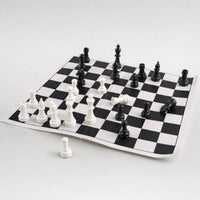 A generic basic plastic chess set on a creased paper board